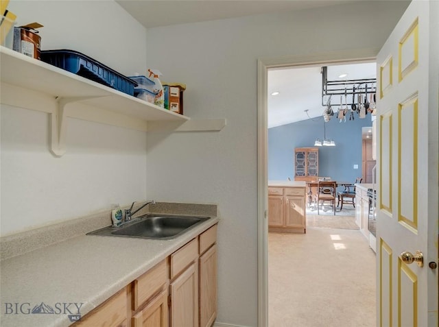 interior space with open shelves, light brown cabinets, light countertops, and a sink