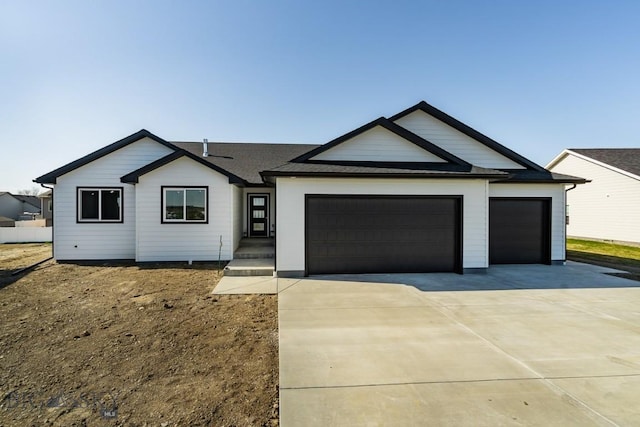 view of front of house with roof with shingles, concrete driveway, and an attached garage