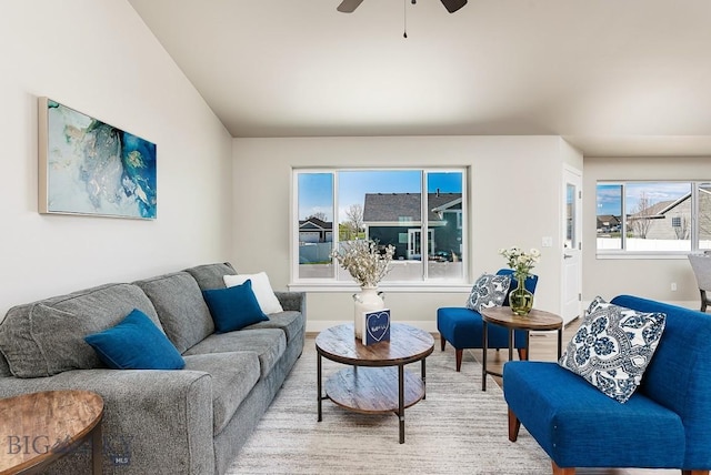 living area with baseboards, wood finished floors, and a ceiling fan