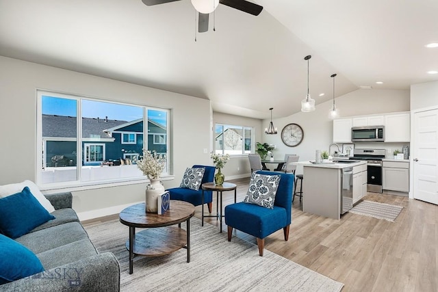 living room featuring ceiling fan, baseboards, vaulted ceiling, recessed lighting, and light wood-style flooring