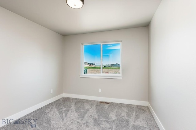 carpeted spare room with visible vents and baseboards