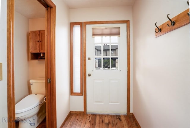 entryway with light wood-type flooring and baseboards