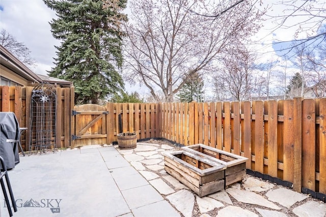 view of patio featuring a fire pit, fence, and a gate