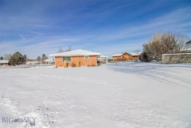 yard layered in snow with fence