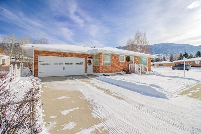 ranch-style home featuring concrete driveway, an attached garage, and brick siding