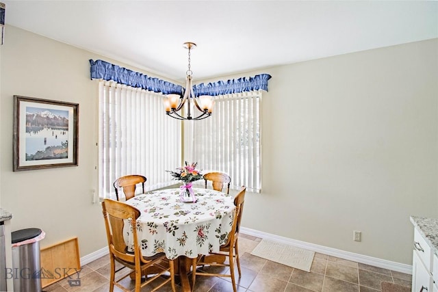 dining room featuring baseboards, a notable chandelier, and light tile patterned flooring