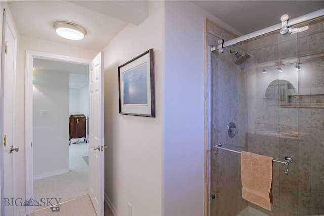 bathroom featuring a shower stall and baseboards