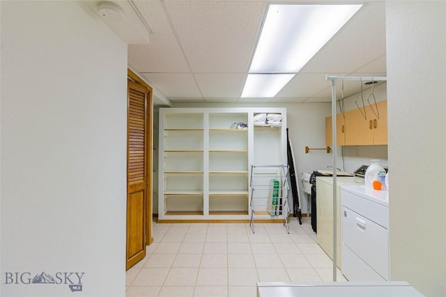 washroom featuring light tile patterned flooring, cabinet space, and separate washer and dryer