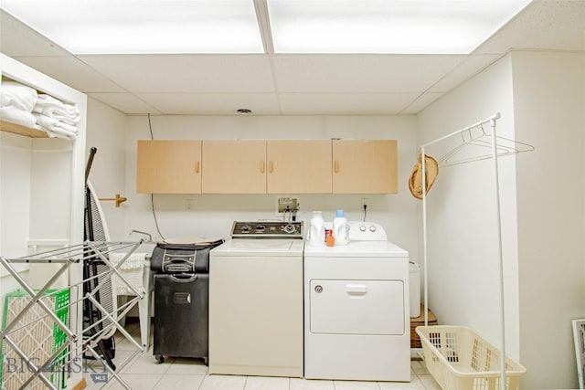 washroom featuring light tile patterned floors, cabinet space, and washer and clothes dryer