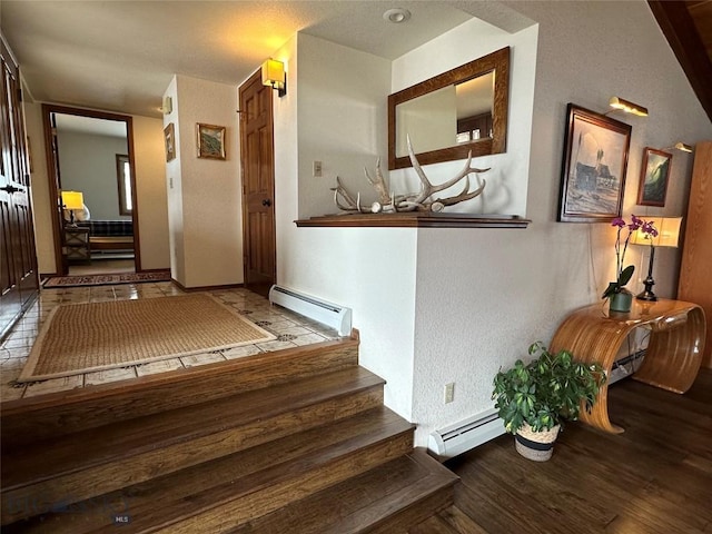 stairs with wood finished floors, baseboards, and a baseboard radiator