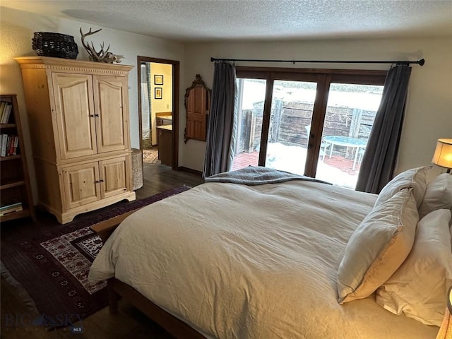 bedroom featuring ensuite bathroom, a textured ceiling, access to exterior, and dark wood finished floors