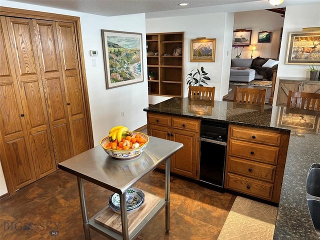 kitchen featuring brown cabinetry and dark stone countertops