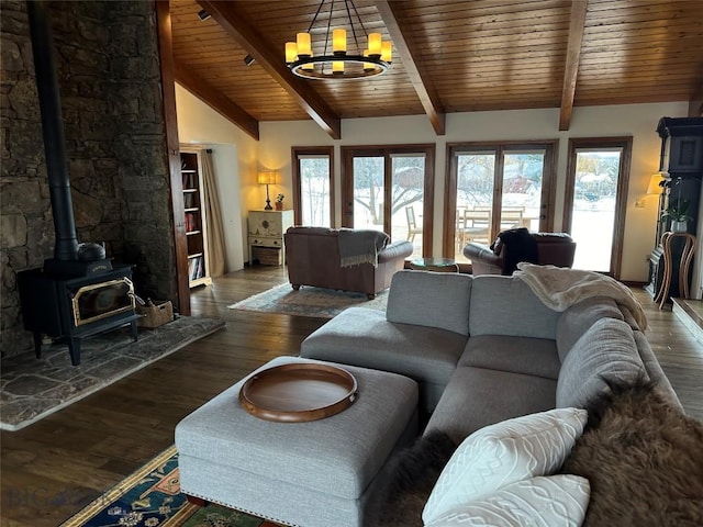 living area featuring a wealth of natural light, lofted ceiling with beams, wood finished floors, and an inviting chandelier