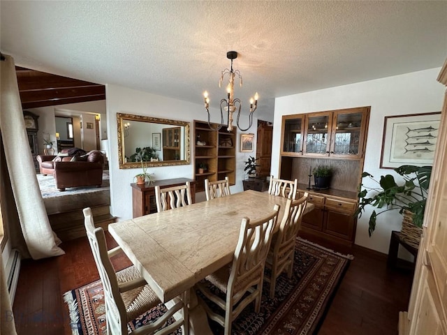 dining space featuring dark wood-style floors, a textured ceiling, and an inviting chandelier