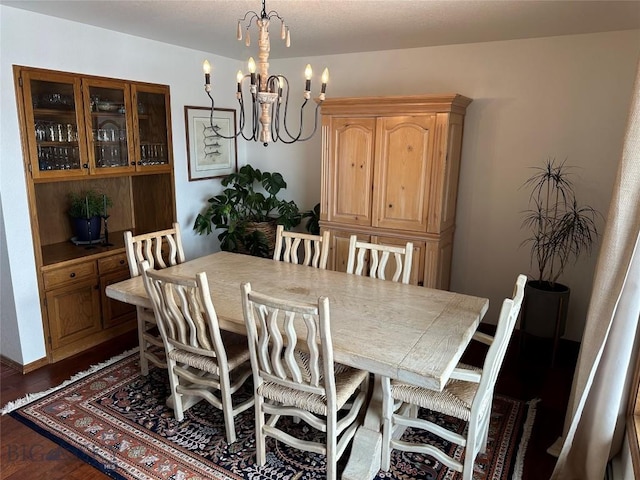 dining room featuring dark wood-style floors and a chandelier