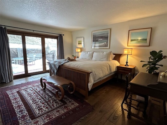 bedroom featuring access to exterior, dark wood finished floors, and a textured ceiling