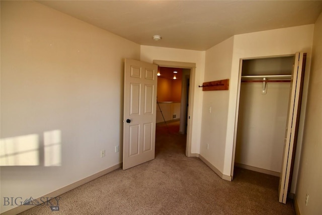 unfurnished bedroom with a closet, baseboards, and carpet floors