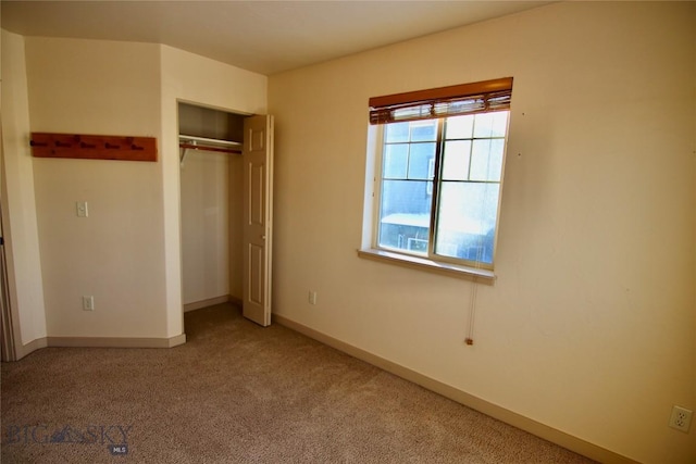 unfurnished bedroom with a closet, baseboards, and carpet floors