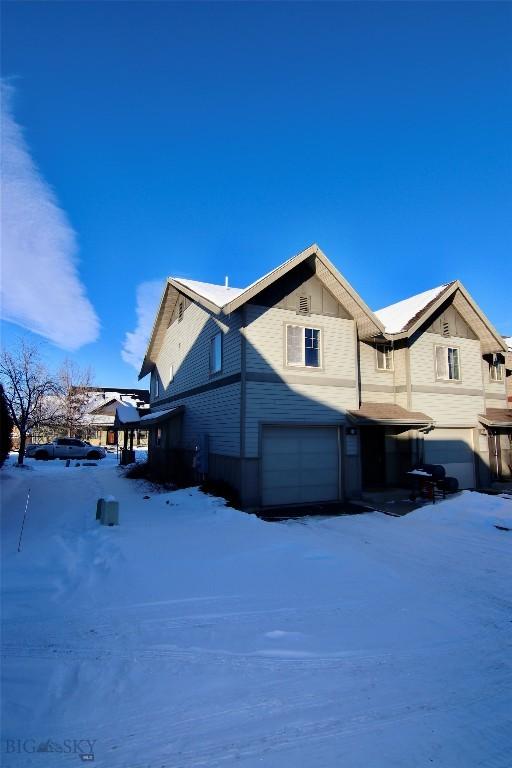 view of snowy exterior with a garage