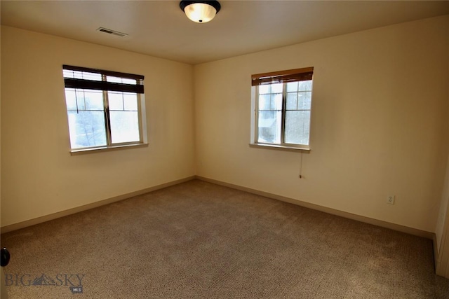 carpeted empty room featuring visible vents and baseboards