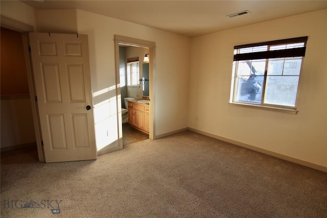 unfurnished bedroom with visible vents, multiple windows, light colored carpet, and baseboards