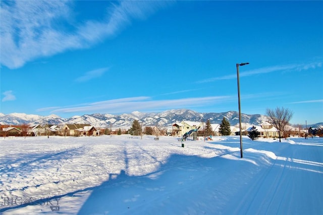 yard layered in snow with a mountain view