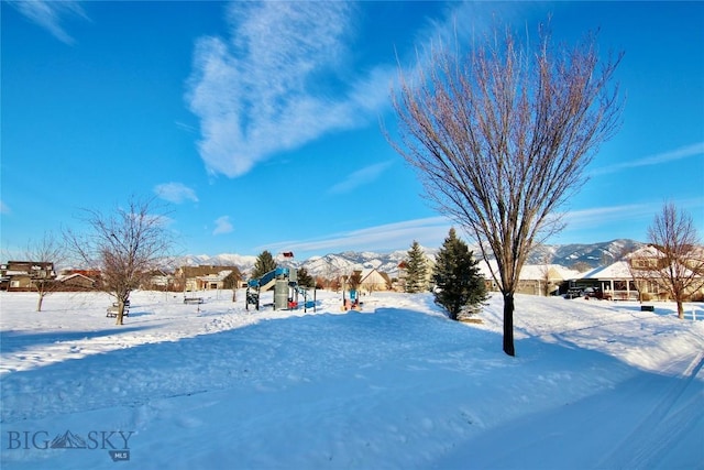 snowy yard featuring a playground