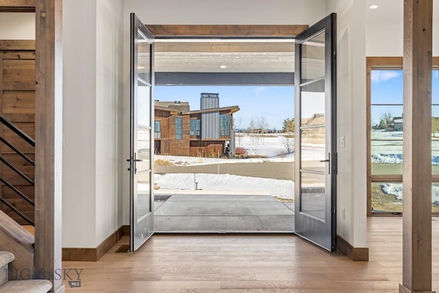 doorway with baseboards and wood finished floors