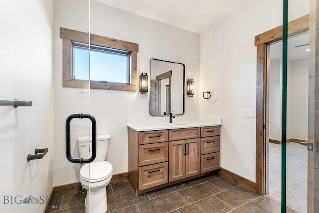 bathroom featuring toilet, vanity, and baseboards