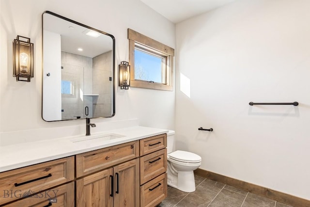 bathroom with vanity, baseboards, a stall shower, tile patterned floors, and toilet