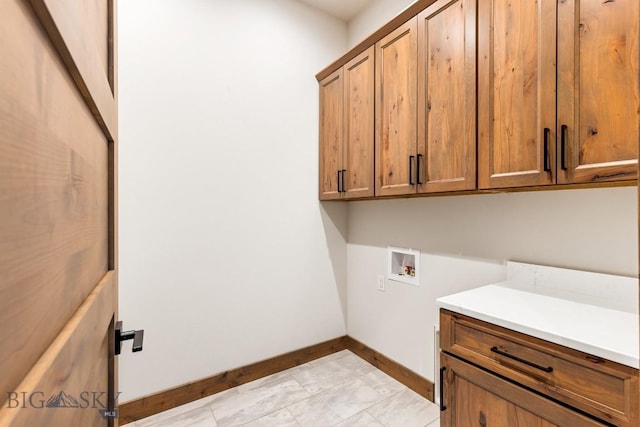 laundry room featuring hookup for a washing machine, cabinet space, and baseboards