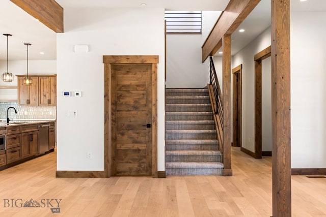 stairway with beamed ceiling, recessed lighting, wood finished floors, and baseboards