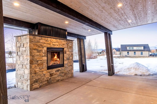 snow covered patio featuring a fireplace