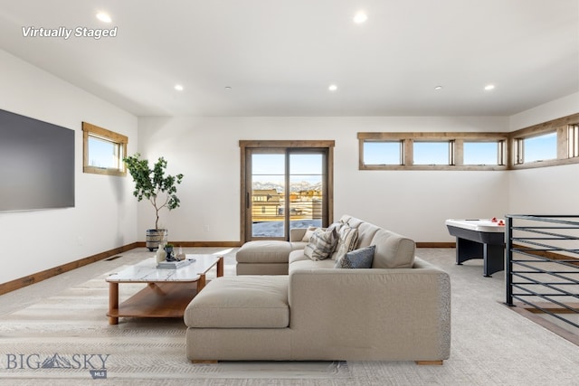 living area featuring recessed lighting, a healthy amount of sunlight, and baseboards