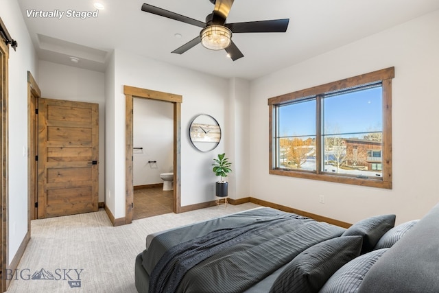 bedroom with baseboards, carpet, ensuite bath, and a ceiling fan