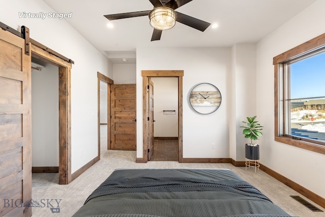 bedroom with a barn door, recessed lighting, baseboards, and visible vents