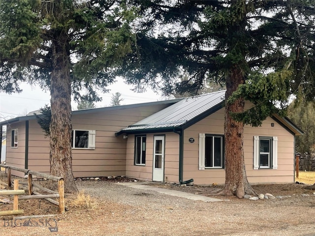 ranch-style home with driveway and metal roof