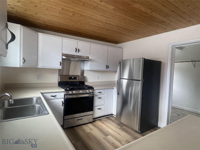 kitchen with a sink, under cabinet range hood, stainless steel appliances, white cabinets, and wooden ceiling