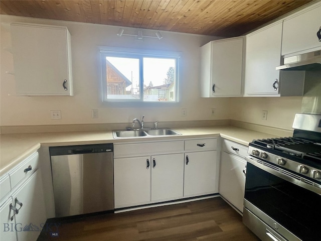 kitchen with a sink, under cabinet range hood, wood ceiling, stainless steel appliances, and dark wood-style flooring