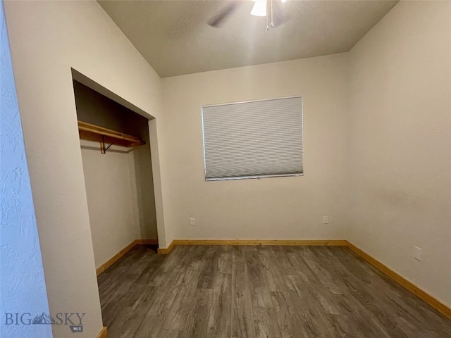 unfurnished bedroom featuring a closet, a ceiling fan, baseboards, and wood finished floors