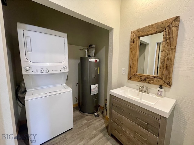 clothes washing area featuring stacked washer and clothes dryer, a sink, water heater, light wood finished floors, and laundry area