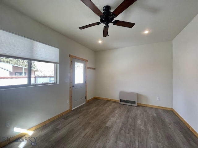 unfurnished room with baseboards, recessed lighting, wood finished floors, heating unit, and a ceiling fan