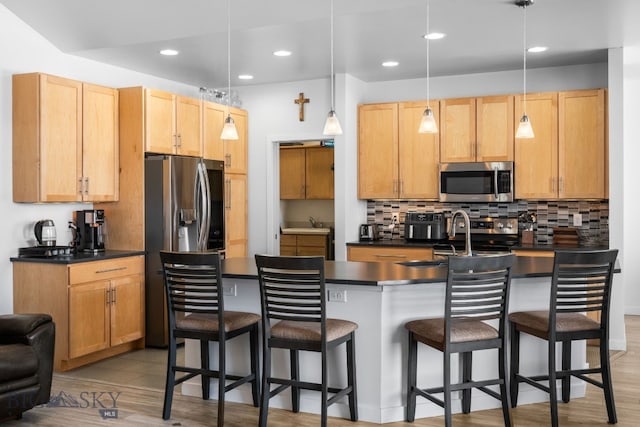2465 Lasso Ave, Bozeman, MT 59718 - kitchen featuring stainless steel appliances, dark countertops, a kitchen breakfast bar, recessed lighting, and tasteful backsplash