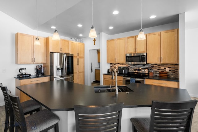 2465 Lasso Ave, Bozeman, MT 59718 - kitchen with stainless steel appliances, dark countertops, decorative backsplash, a breakfast bar area, and recessed lighting