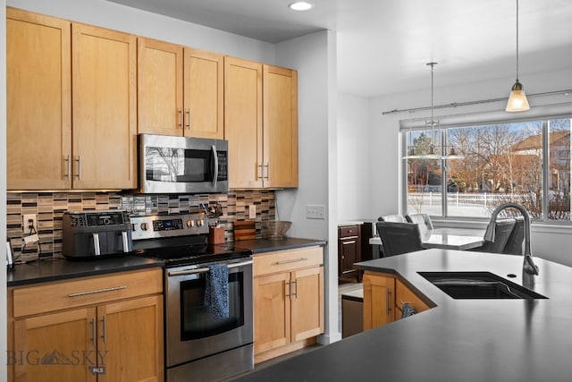 2465 Lasso Ave, Bozeman, MT 59718 - kitchen with stainless steel appliances, dark countertops, decorative backsplash, light brown cabinetry, and pendant lighting