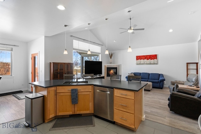 2465 Lasso Ave, Bozeman, MT 59718 - kitchen featuring stainless steel dishwasher, open floor plan, dark countertops, a glass covered fireplace, and high vaulted ceiling