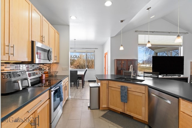 2465 Lasso Ave, Bozeman, MT 59718 - kitchen featuring appliances with stainless steel finishes, dark countertops, light brown cabinetry, decorative backsplash, and recessed lighting