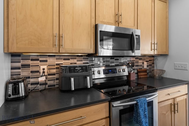 2465 Lasso Ave, Bozeman, MT 59718 - kitchen with stainless steel appliances, dark countertops, tasteful backsplash, and light brown cabinets