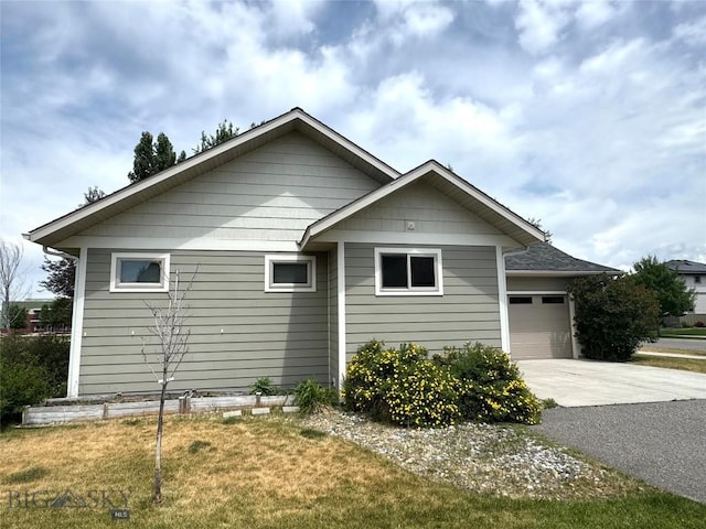 2465 Lasso Ave, Bozeman, MT 59718 - view of side of property with driveway, an attached garage, and a lawn