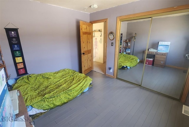 bedroom featuring a closet, baseboards, and wood finished floors